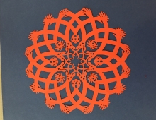 an intricate orange paper craft decoration created by Allan Troxler ’69 